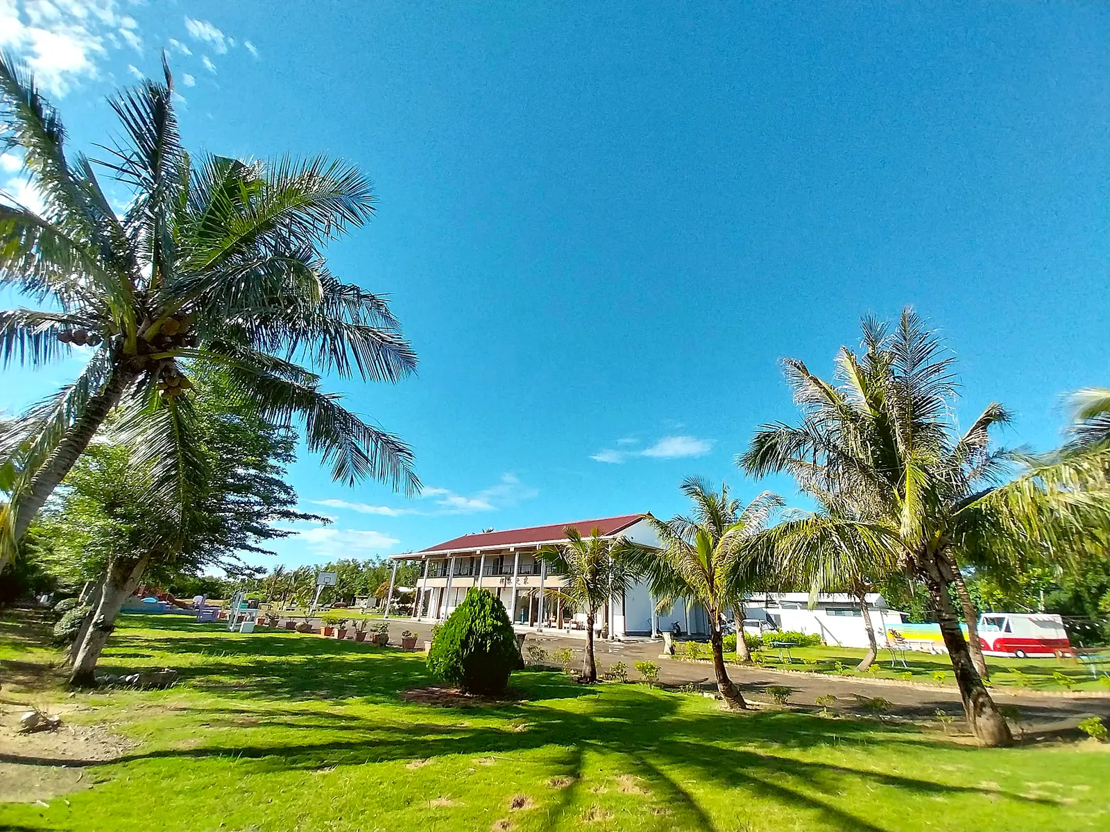 The coconut-palm-wrapped main building of Coconut Palm Home, with wide lawns in front